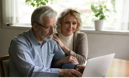 elderly couple watch webinar together on the computer